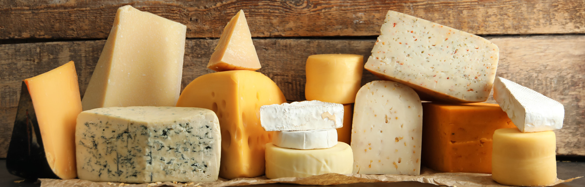 KI generiert: Verschiedene Käsesorten auf einer Holzoberfläche arrangiert.