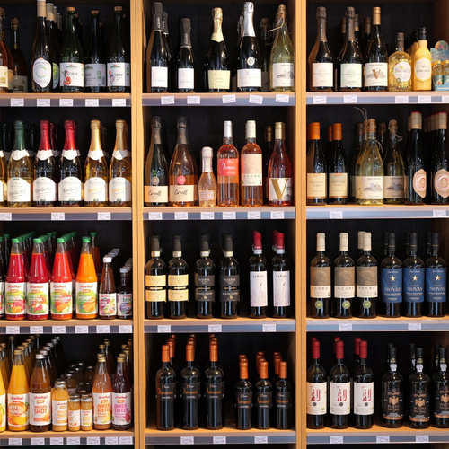 KI generiert: Regale mit verschiedenen Flaschen von Wein, Sekt und Fruchtsäften in einem Geschäft.