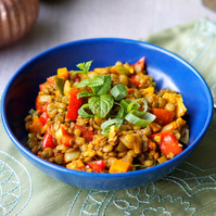 KI generiert: Eine blaue Schale mit Linsengericht, garniert mit Frühlingszwiebeln und Minzblättern.