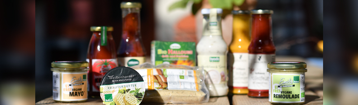 KI generiert: Verschiedene Bio-Lebensmittelprodukte auf einem Tisch, darunter Saucen und Aufstriche.