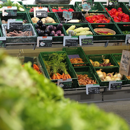 KI generiert: Ein Marktstand mit verschiedenen Gemüsesorten und Preisschildern. Text: "Nicht alles" und diverse Gemüse.